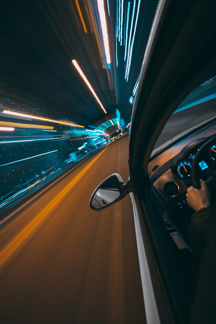 Dramatic motion blur on a city road from a car, capturing speed and night lights.